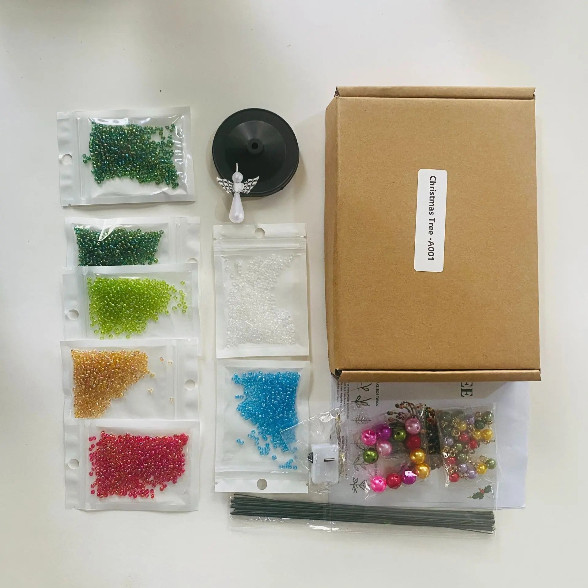 DIY beaded Christmas tree kit package with colorful beads, base, angel topper and assembly supplies